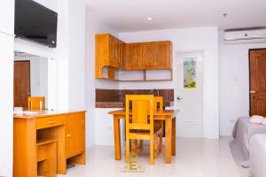 una cocina con armarios de madera, mesa y sillas en Empress Island Hotel, en Alaminos