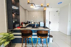 a kitchen with a counter with stools in it at Onsen Premium Suites @ Tambun Ipoh in Ipoh