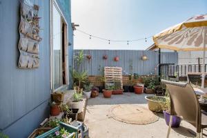 un patio con un montón de macetas y una sombrilla en Casa Altavista, en Valparaíso