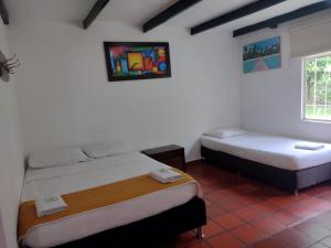 um quarto com duas camas e uma janela em Hotel Playa By Marbar em Villeta