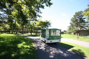 a green and white bus driving down a road at Karuizawa Prince Hotel West in Karuizawa