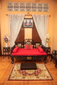 een slaapkamer met een rood bed in een kamer bij บ้านกิจเสรี 