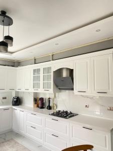 uma cozinha branca com armários brancos e um fogão em CMH em Rize