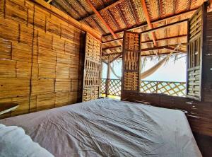 Cama grande en habitación con ventana en Hostal halaliku, en Santa Marta