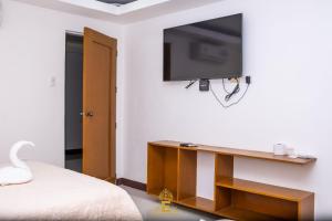 1 dormitorio con TV en la pared y 1 cama en Empress Island Hotel en Alaminos