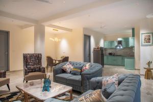 ein Wohnzimmer mit blauen Sofas und eine Küche in der Unterkunft Mystic Hill Crest Luxurious 2 BHK Apartments in Kasauli