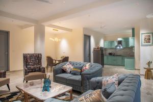 a living room with blue couches and a kitchen at Mystic Hill Crest Luxurious 2 BHK Apartments in Kasauli