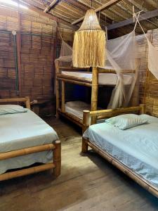 a room with two bunk beds and a lamp at Hostal halaliku in Santa Marta