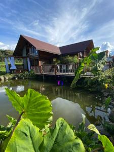 a house with a pond in front of it at Chalet del lago Santa Elena in Santa Elena