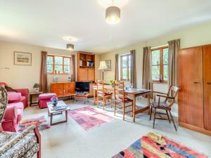 a living room with a couch and a table at Water Hall Cottage in Chelsworth