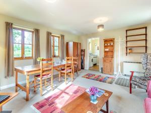 a living room with a table and a dining room at Water Hall Cottage in Chelsworth