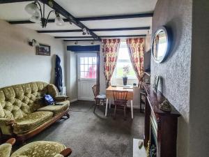 uma sala de estar com um sofá e uma mesa em Cosy Cottage em Allonby