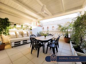 a patio with a table and chairs and a couch at Penthouse in the heart of Bari with terrace in Bari