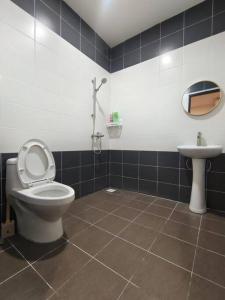 een badkamer met een toilet en een wastafel bij Sakura homestay 5 bedrooms - Spring Lopeng 14 pax in Miri