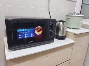 a microwave oven sitting on a counter in a kitchen at Sakura homestay 5 bedrooms - Spring Lopeng 14 pax in Miri