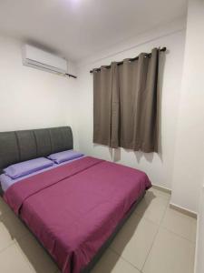 Un dormitorio con una cama con sábanas moradas y una ventana en Sakura homestay 5 bedrooms - Spring Lopeng 14 pax en Miri