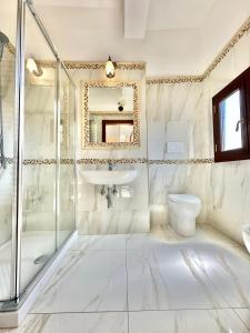 uma casa de banho branca com um lavatório e um WC em PENSIONE ITALIA em Bolsena