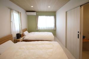 a bedroom with two beds and a window at misora 合津港近く松島の自然と海を満喫できる平屋の貸切別荘 in Kami Amakusa