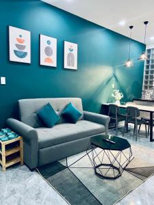 ein Wohnzimmer mit einem Sofa und einer blauen Wand in der Unterkunft Su Apartment in Da Lat