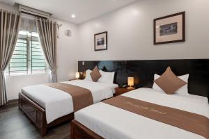 a hotel room with two beds and a window at Truong An NoiBai Airport Hotel in Noi Bai
