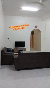 a living room with a couch and a tv at EZ Homes Lundang Kota Bharu in Kota Bharu +1 photo