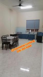 ein Esszimmer mit einem Tisch und Stühlen in einem Zimmer in der Unterkunft EZ Homestay Lundang Kota Bharu in Kota Bharu