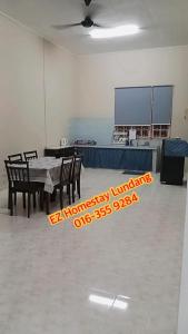 a dining room with a table and chairs in a room at EZ Homes Lundang Kota Bharu in Kota Bharu