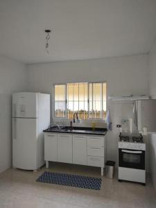 a kitchen with a refrigerator and a sink and a stove at Casa bem localizada in Guarujá +7 photos