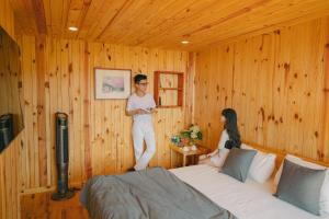 a man and a woman standing in a bedroom at Lavender Dalat Hotel and Resorts in Da Lat