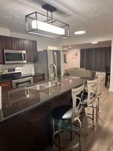 a kitchen with a counter with chairs and a sink at Elk lake trail side suite in Victoria