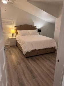 a bedroom with a large bed with white sheets at Elk lake trail side suite in Victoria