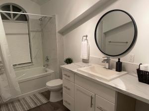 Baño blanco con lavabo y espejo en Elk lake trail side suite en Victoria