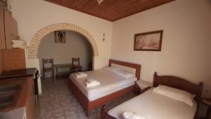 a bedroom with two beds and a sink and a table at Honey-House “Kastrioti” in Përmet