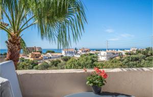 a table with flowers on a balcony with a palm tree at Cozy Apartment In Mijas With Swimming Pool in Mijas