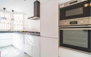 a kitchen with white cabinets and a stove at Cozy Apartment In Mijas With Swimming Pool in Mijas