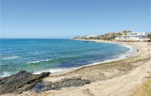 a beach with people walking on the sand and the water at Cozy Apartment In Mijas With Swimming Pool in Mijas