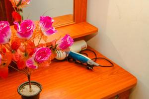 a desk with a mirror and flowers on it at Senura Home Stay in Sigiriya