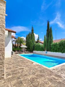 a swimming pool in the yard of a house with trees at Ayia Napa Villa with private pool in Ayia Napa