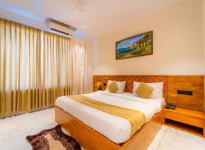 a bedroom with a large bed and a window at Red Button Resort in Mahabaleshwar