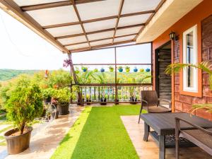 an outdoor patio with a table and chairs and grass at Red Button Resort in Mahabaleshwar