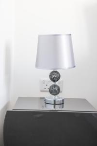 a table with a lamp on top of it at Stunning Two-Bedroom Apartment at A3REE, Free Parking, near Cribbs Causeway Mall in Bristol