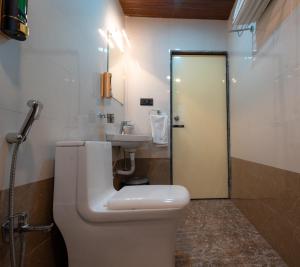 a bathroom with a toilet and a sink at Red Button Resort in Mahabaleshwar