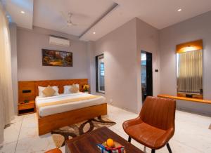 a bedroom with a bed and a table and a chair at Red Button Resort in Mahabaleshwar