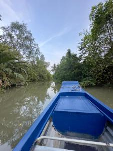 ein blaues Boot im Wasser auf einem Fluss in der Unterkunft Boutique Lodge Can Tho Homestay in Cần Thơ