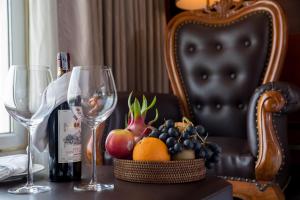 a table with two wine glasses and a basket of fruit at Samdi Hotel in Danang
