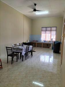 a living room with a table and chairs and a kitchen at EZ Homes Lundang Kota Bharu in Kota Bharu