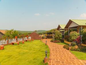 a row of benches on a lawn in a yard at Red Button Resort in Mahabaleshwar