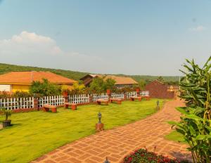 a park with benches and a white fence at Red Button Resort in Mahabaleshwar