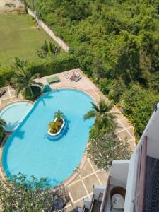 - une vue sur la piscine avec un bateau dans l'établissement sea sand sun resort Executive Mae Rumphueng beach, à Rayong