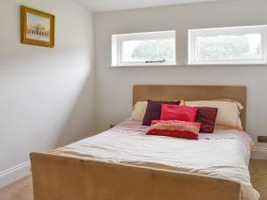 a bed in a room with two windows at The Lodge - Oakwood Park Polo Club in Maresfield